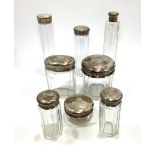 An eight-piece dressing table set of silver topped toilette jars, all by William Aitken,
