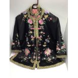 A ladies, or young girls Chinese black silk jacket, worked with birds amidst flowering branches