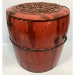 A red stained, carved wooden Chinese rice barrel, of typical cylindrical form, with brass lock and