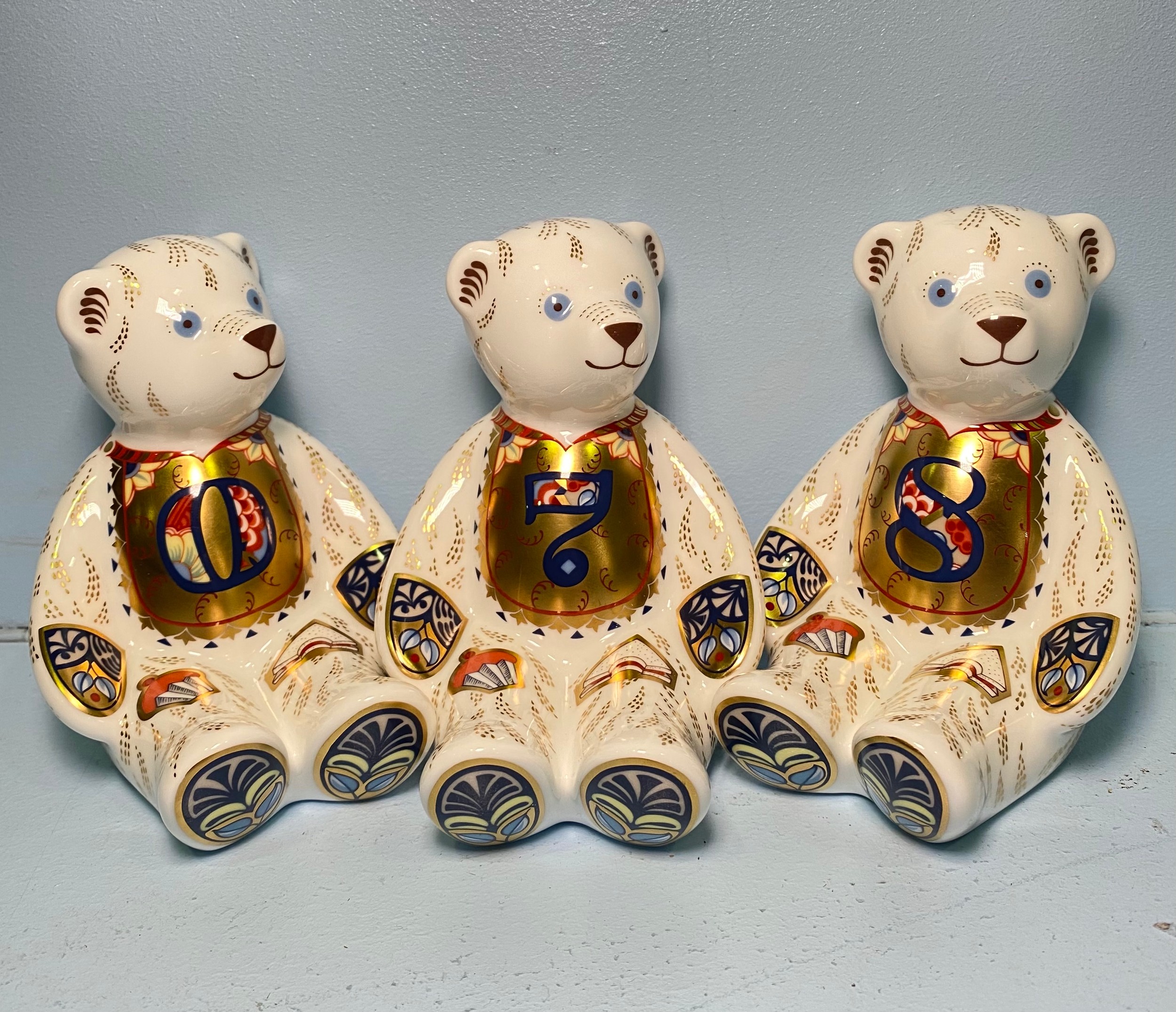 Three Royal Crown Derby Number Bears, '0' and '7' and '8', with printed marks to base, gold stoppers