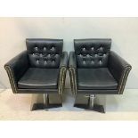 A pair of black vinyl hair stylists chairs with diamante studded backs and foot-pedal height