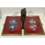 Two pairs of framed embroidered Chinese earmuffs, together with a carved Black Forest nutcracker