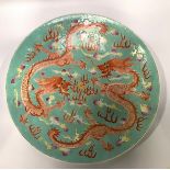 A Chinese porcelain charger, on a turquoise ground, enamel decorated with two iron red five-claw