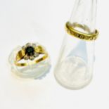 An 18ct yellow gold cluster design dress ring, set with a round faceted sapphire to the centre and