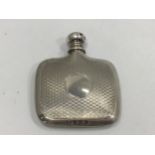 A silver scent bottle modelled as a hip flask with engine turned decoration and screw off top, (un-
