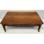 A miniature mahogany dining table, of typical rectangular form, raised on turned supports to brass