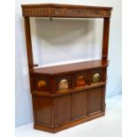 A free standing oak drinks bar with carved panels, coloured bullseye glass panels, the top with