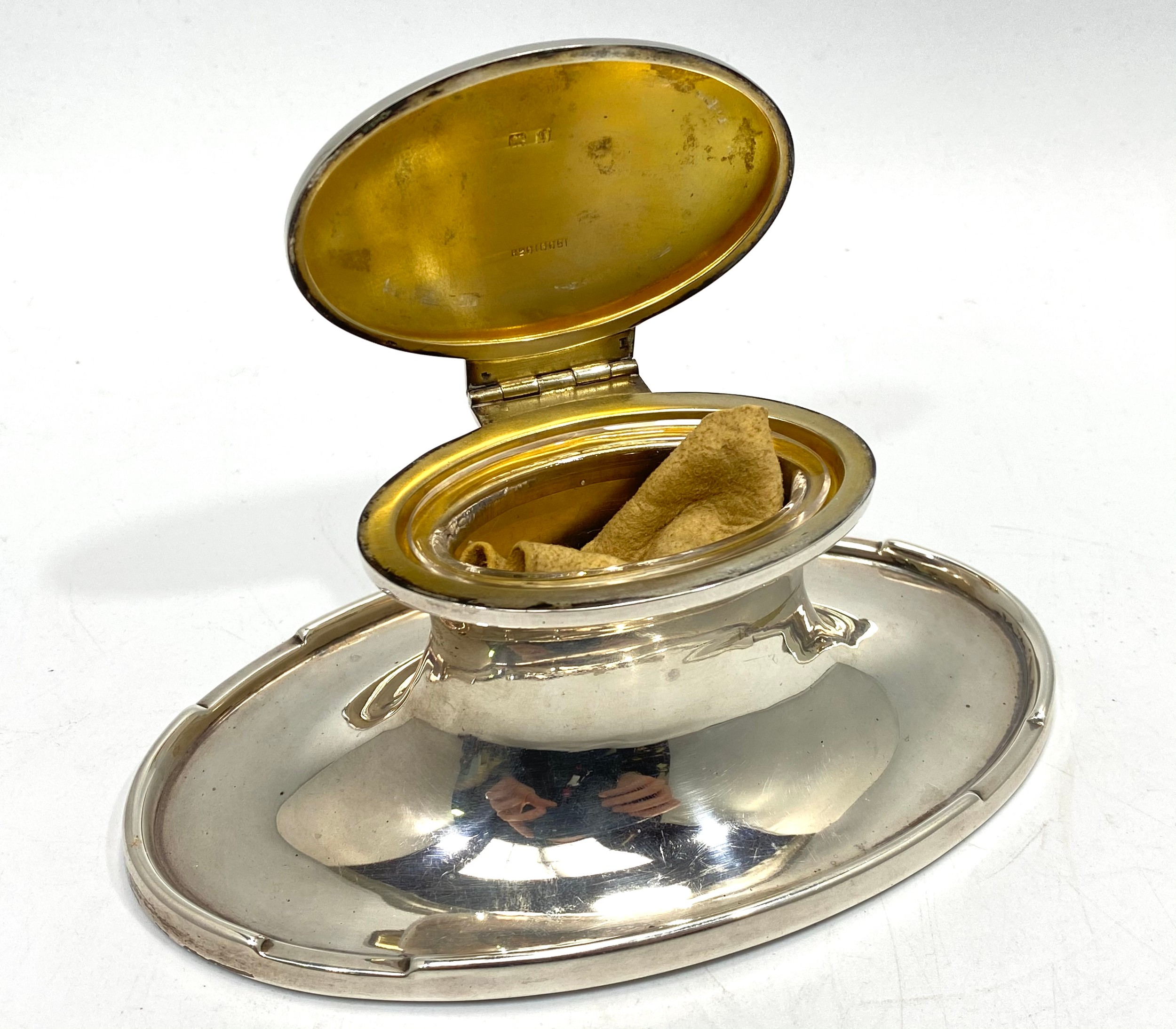 An Asprey's of London loaded silver inkwell of oval waisted form, with clear glass liner and