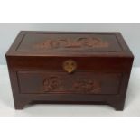A camphor wood lined Chinese blanket chest, carved with scenes of figures and buildings, interior