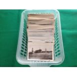 A plastic tray containing approximately 300 standard-size postcards. One has a small part of the