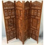 A 19th century carved and pierced walnut four-fold dressing screen in the Persian style, 182cm x