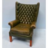 A green leather deep-button wing-back armchair, with horse-hair filling, loose cushion, close-