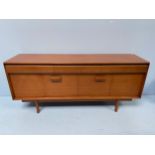 A 1960s Teak sideboard, with three mahogany lined and dovetailed frieze drawers above a pair of