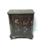 A 20th century oriental lacquered cupboard with rectangular top and curved corners, panelled doors