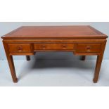 A Chinese teak desk, with three-frieze drawers, each with carved, flush handles and raised on