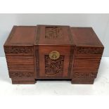 A camphor-lined Chinese trunk with carved and stepped cover, central scene of figures and