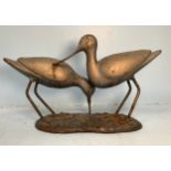 A 20th century painted and gilded metal sculpture of a pair of wading birds, on naturalistic base,