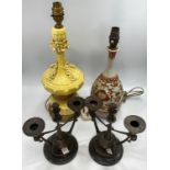 A pair of French bronze twin-branched candelabra modelled as twin handled urns surmounted with a