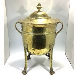 A brass twin-handled coal bin, with circular lid enclosing metal liner, raised on four supports with