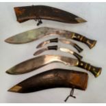 A pair of WWII era Kukri knives, with brass bound handles, in original leather scabbards, 29cm