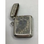 A silver vesta case with heart shaped cartouche (un-engraved) within floral and foliate engraved