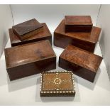 A graduated set of three burr wood boxes, together with two further similar boxes and a