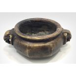 A Chinese bronze incense burner, of octagonal form with circular rim and elephant mask handles,