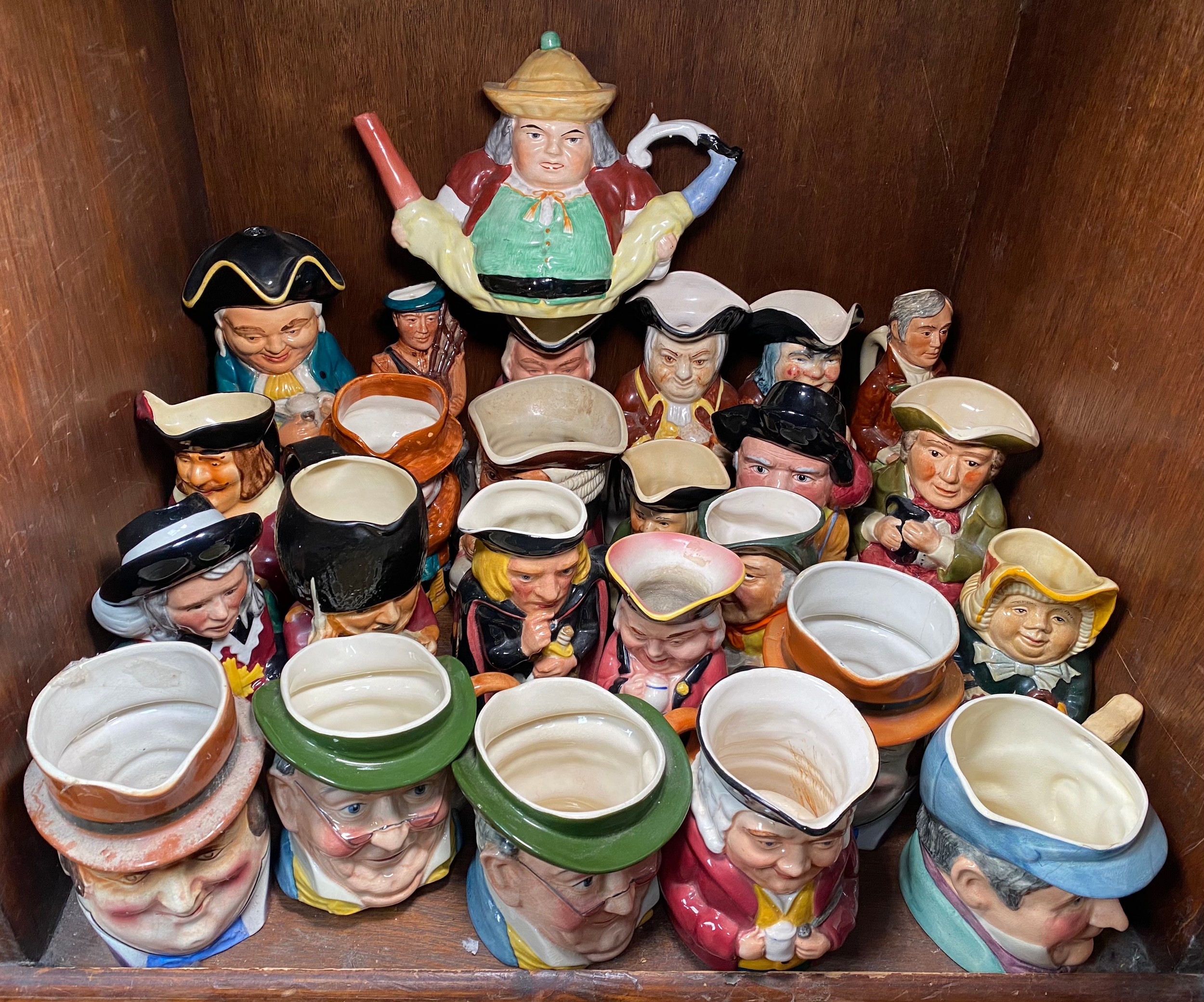 A Toby Peg Leg teapot together with approximately 30 medium to large toby jugs/character jugs/