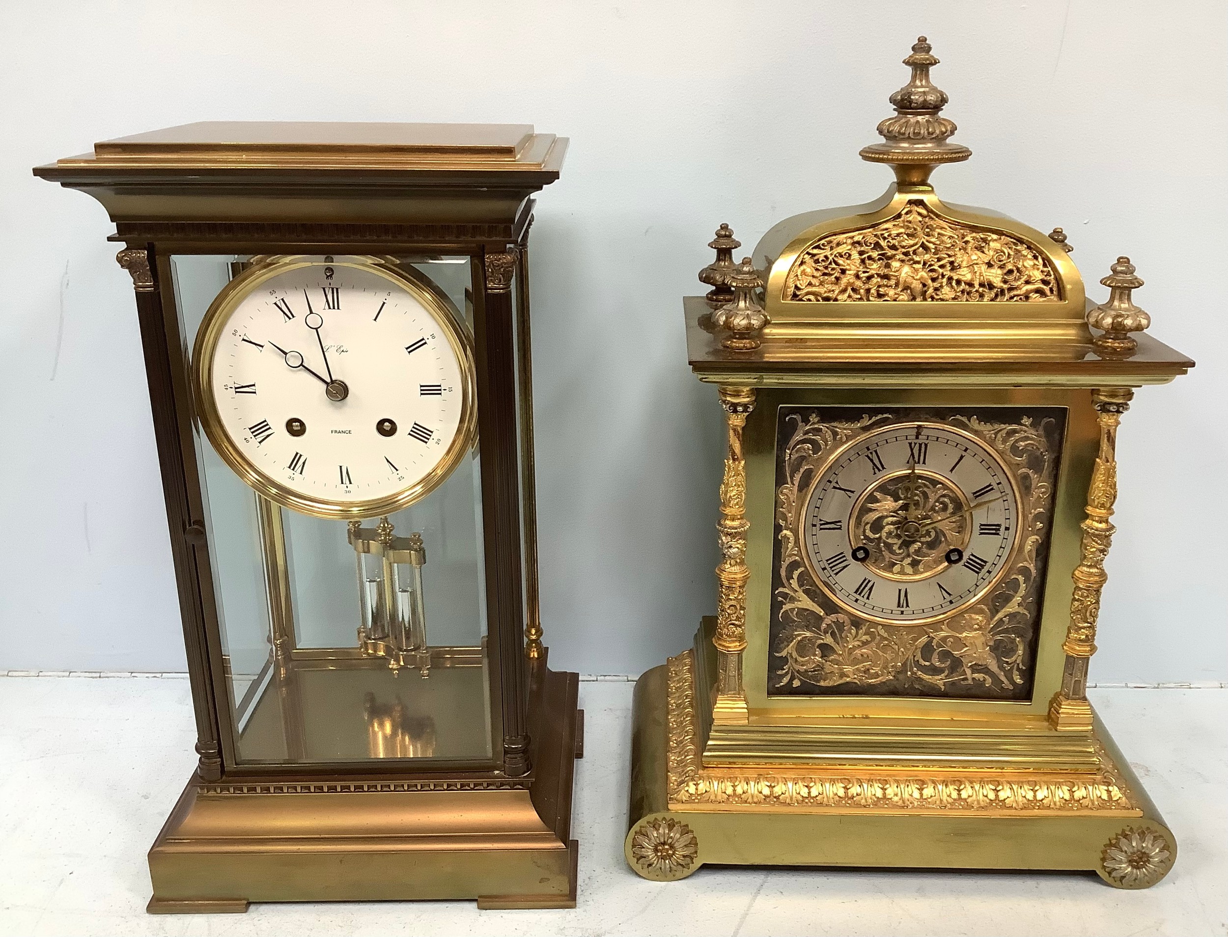 A French brass and four glass mantel clock by L'Epee, the white enamel dial with Roman numerals