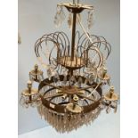 A large circular chandelier, the top with arched gilt arms to cut glass crystal drops above a set of