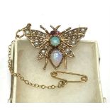 A 9ct gold brooch modelled as a butterfly, the wings set with seed pearls, two opals to the