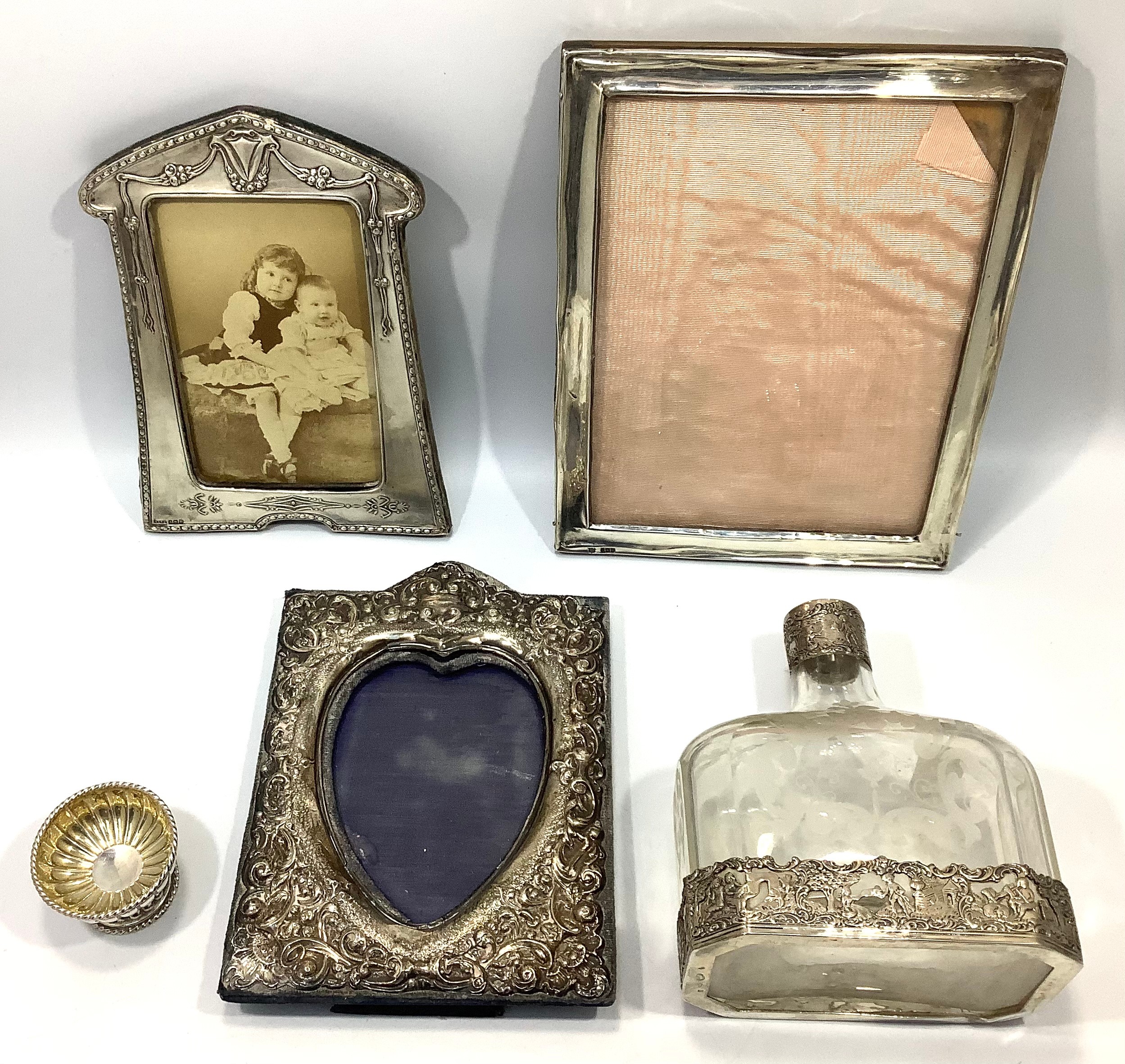 Three various silver photo frames including one with a heart shaped aperture, together with a