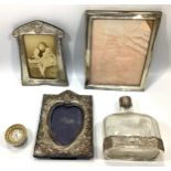 Three various silver photo frames including one with a heart shaped aperture, together with a
