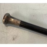 A silver topped walking stick with ebony shaft, the top engraved with foliate panels, London,