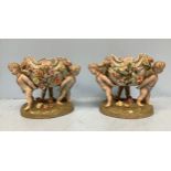 A pair of German porcelain centrepieces/fruit bowls modelled with three cherubs supporting a