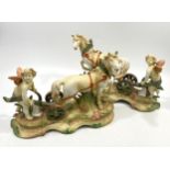 A pair of porcelain figure-groups depicting cherubs with horses, raised on naturalistic bases,