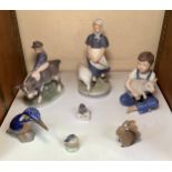 A collection of seven assorted Royal Copenhagen porcelain figures comprising a boy holding a pig,