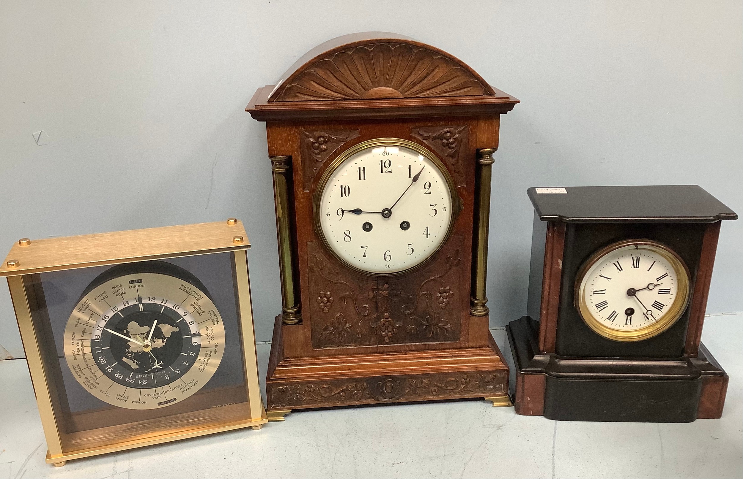 A French mantel clock, the white enamel dial with Arabic numerals denoting hours, in ornately carved