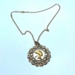 A 9ct gold large round pendant with Egyptian head in the centre, suspended on a 9ct yellow gold