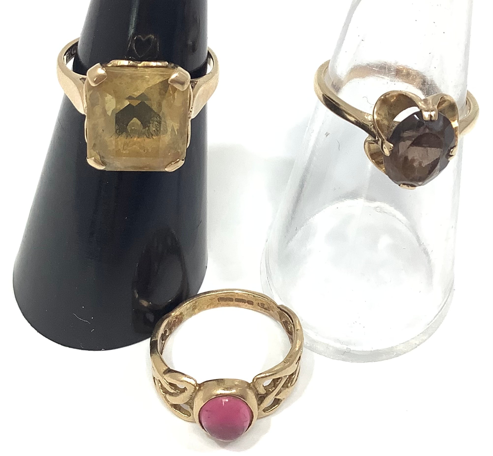 Three 9ct gold dress rings including a square citrine, oval smoky quartz and a cabochon pink stone