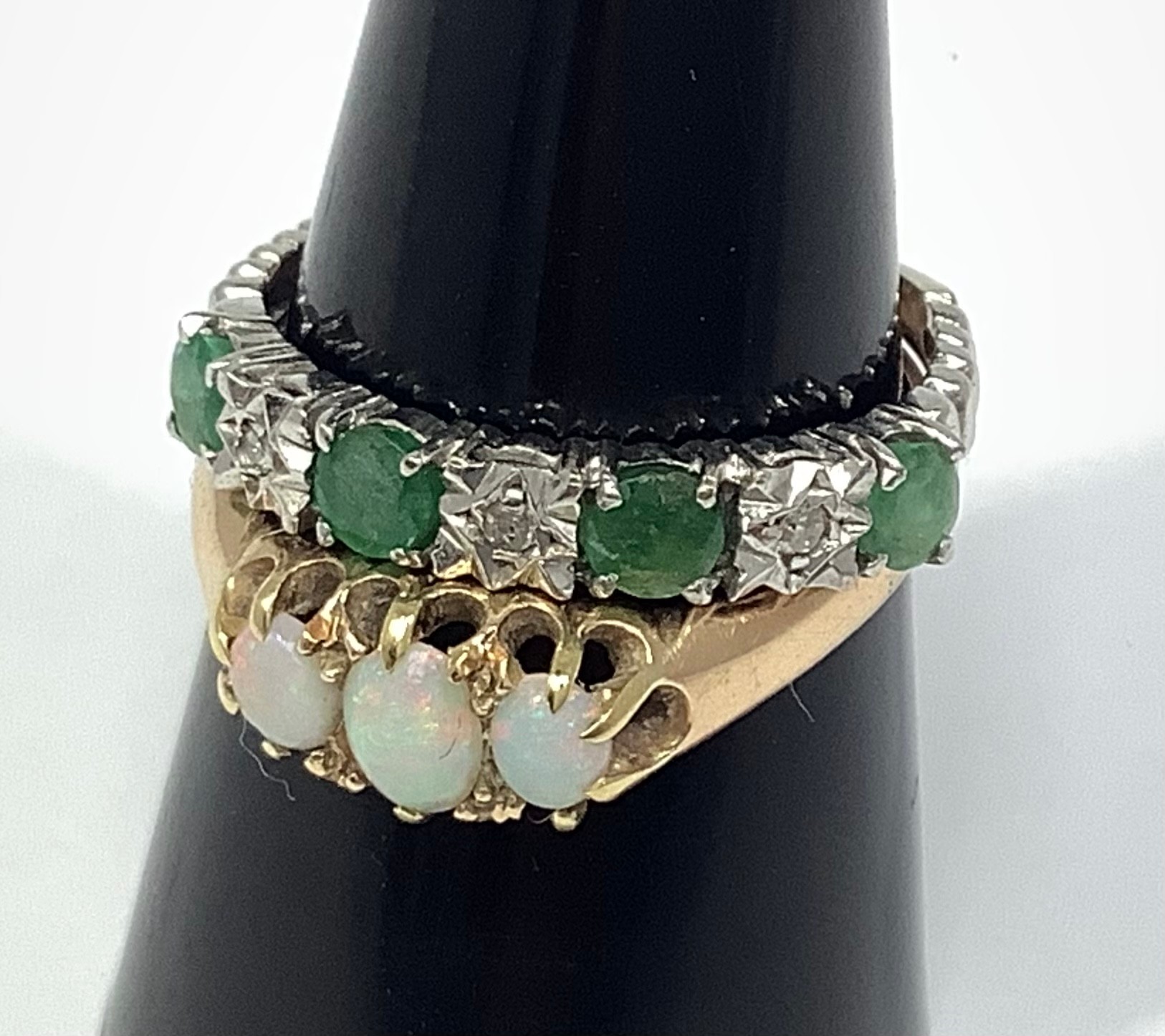 A 9ct white gold ring set with four emerald coloured stones and three small diamonds, together