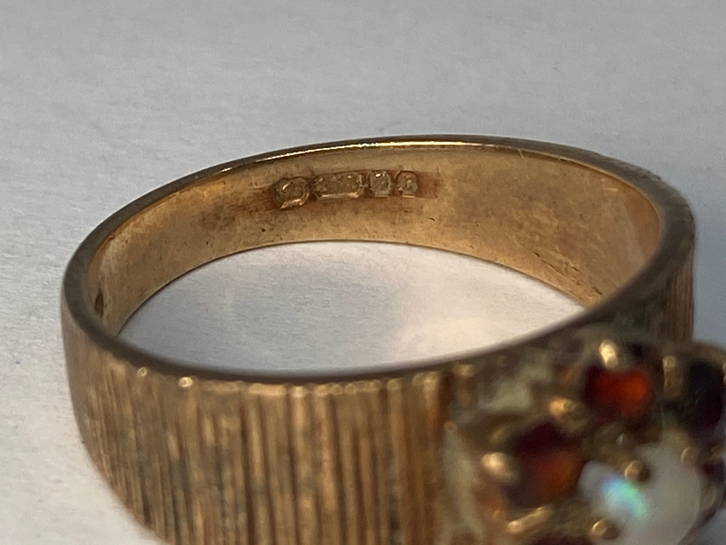 A 9ct gold ring with textured shank, set with an opal to the centre with garnets surrounding, ring - Bild 2 aus 3