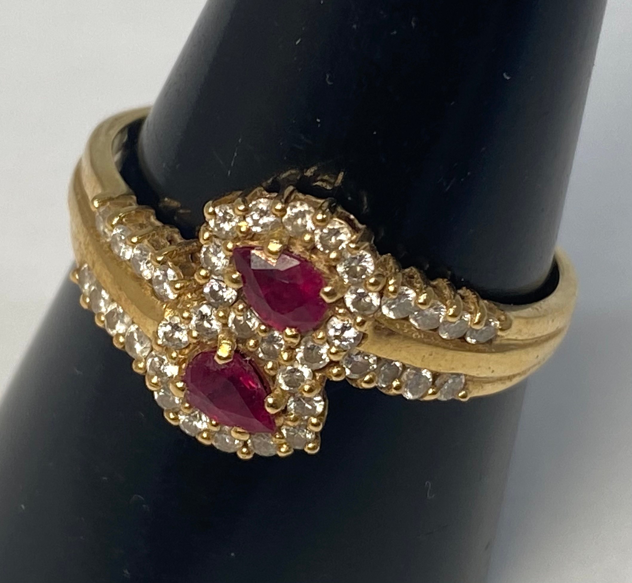 An 18ct gold ruby and diamond ring, set with 2 x pear shaped rubies and 38 x small round brilliant