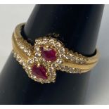 An 18ct gold ruby and diamond ring, set with 2 x pear shaped rubies and 38 x small round brilliant