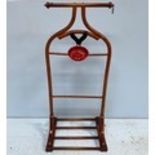A mahogany clothes/suit stand, with metal suspension rings to each side of top rail, above a metal