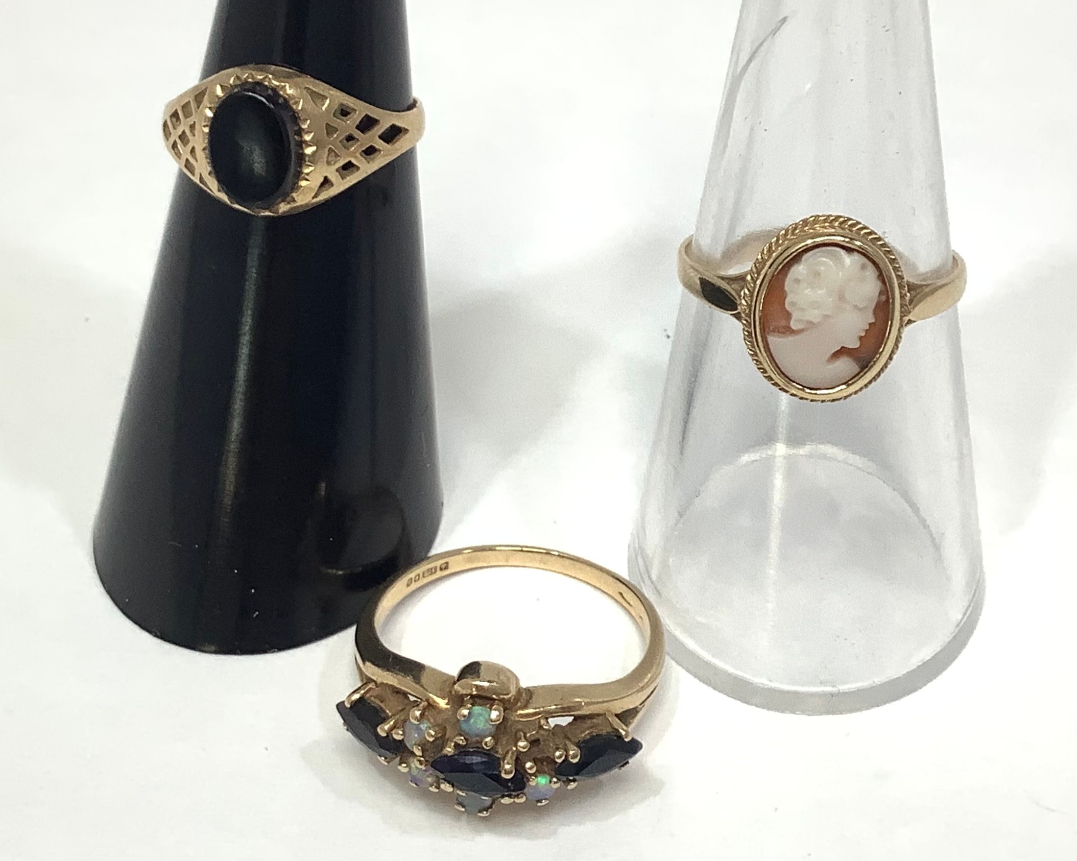 Three 9ct gold dress rings including a cameo, a black onyx signet ring and another set with small