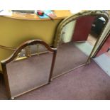 A gilt-framed over-mantel mirror with arched top and bevelled glass, 125x107xm, and a mahogany