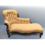 A Victorian stained mahogany chaise lounge with gold and floral fabric upholstery, raised on