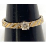 An 18ct gold bi-colour ring, set with a solitaire round brilliant cut diamond weighing an