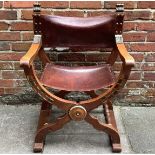 An early 20th century oak Savonarola / Dante chair with brown leather studded back and seat,